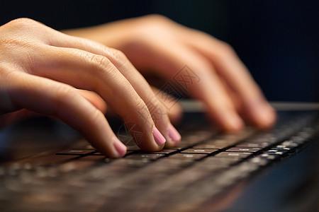 商业教育技术女的手与笔记本电脑打字晚上用笔记本电脑打字女的手